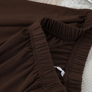 Primer plano de la cintura elástica marrón del pijama con pliegues y etiqueta de talla L