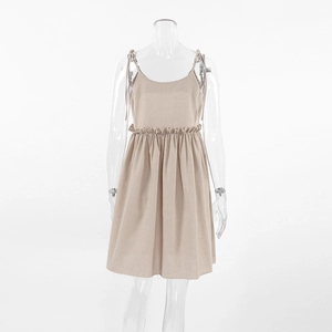 Detail of beige cotton linen nightdress featuring delicate bow straps and ruffled waistline