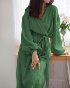 Detailed texture of dark green double-layer muslin cotton bathrobe with waist tie and lantern sleeves