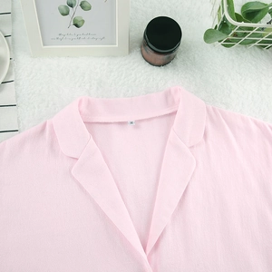 Détail du col à revers et de la texture en coton du pyjama rose à volants, étiquette taille M