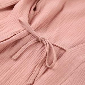 Detail shot of dusty pink double-layer gauze fabric with soft texture and tie-bow knot