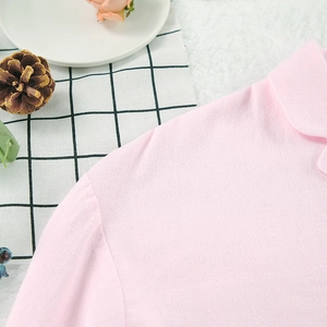 Détail d'un pyjama en coton rose avec col à revers classique et texture à volants doux
