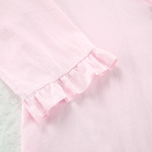 Détail du tissu en coton rose avec des bords à volants et une texture douce