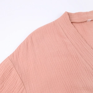 Detail of V-neck collar and breathable crinkle texture fabric in coral pink cotton
