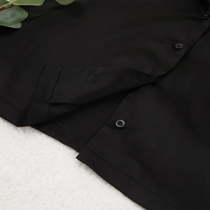 Gros plan sur les boutons à quatre trous et coutures fines du haut de pyjama