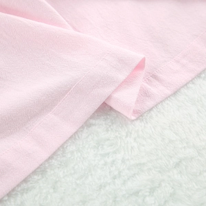 Gros plan de l'ourlet à volants d'un pyjama en coton rose avec des coutures de qualité