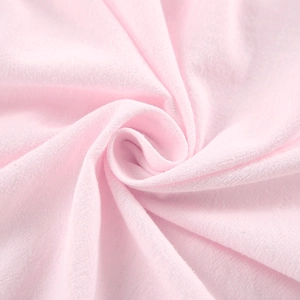 Gros plan sur le tissu en coton rose clair montrant la texture fine et le tissage aéré