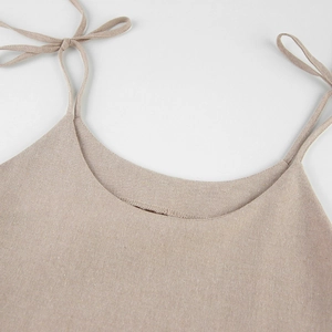 Detail of cotton linen nightdress featuring beige shoulder strap with a delicate bow knot
