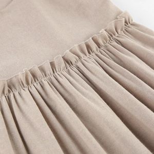 Close-up of cotton linen nightdress featuring ruffle hem detail and fine stitching