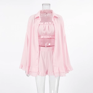 Detail van roze driedelig pyjamaset met ruches en textuur van ademend wafelkatoen