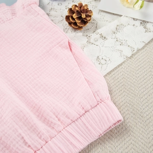 Detailopname van de lichtroze hydrofiel katoenen short met elastische taille en zak