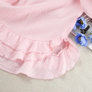 Detail van de roze pyjama met ruches, crinkle-textuur en fijne knoopdetails