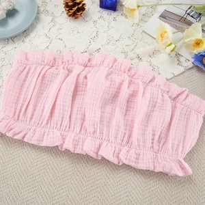 Detailweergave van roze bandeau-top met ruches en natuurlijke katoenen textuur