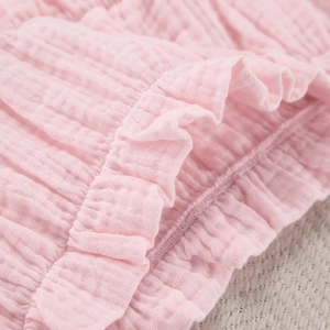 Detailopname van roze ruffles en de textuur van ademend katoenen mousseline weefsel