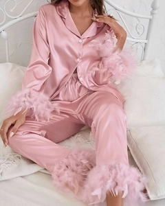 Détail du pyjama en satin rose avec bordures luxueuses en plumes d'autruche