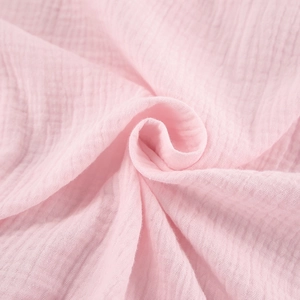 Detail van de textuur van ademende roze dubbele mousseline stof met zachte ruches