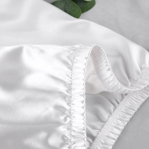 Gros plan détaillé du pyjama en soie glacée blanche avec texture plissée élastique