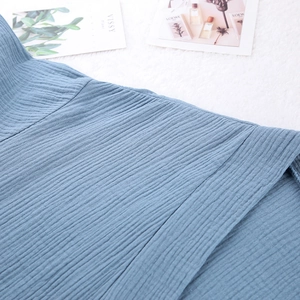 Detail shot of blue crinkled cotton crepe fabric texture on soft plush background