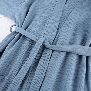 Detailed texture of dusty blue cotton gauze bathrobe with waist tie and soft fabric