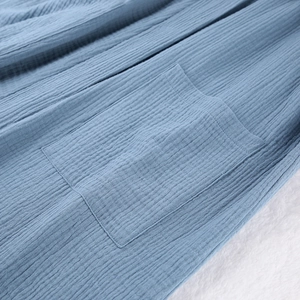 Detail of blue crepe cotton bathrobe featuring a stitched patch pocket and soft texture