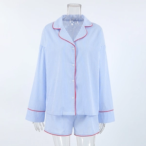 Detail view of cotton striped pajama set with contrasting red piping on the lapel and cuffs