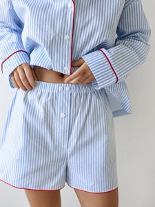Close-up of blue striped cotton pajamas with red contrast piping and white buttons