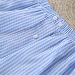 Detail of blue and white striped cotton pajamas featuring elastic waist and white buttons