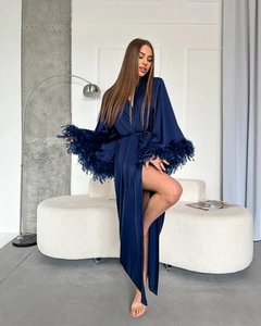 Close-up of deep blue satin robe featuring premium feather trim on long sleeves