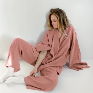 Dettaglio del pigiama in cotone crespo rosa corallo con trama del top ampio e dei pantaloni