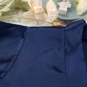 Detail of luxurious dark blue satin fabric with elegant silk sheen and smooth texture