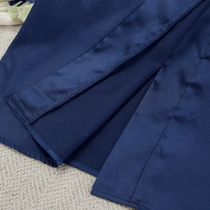 Close-up of deep blue satin robe showing fine hem stitching and smooth fabric texture