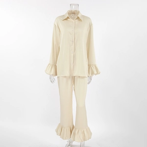 Detailed view of satin pajama set featuring elegant ruffled cuffs and hems on smooth fabric
