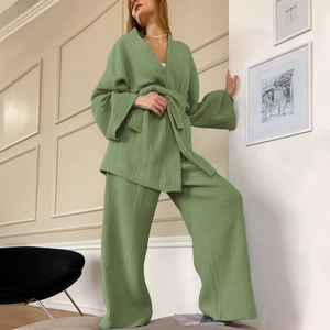 Dettaglio del set pigiama in mussola verde salvia con cintura annodata e pantaloni larghi