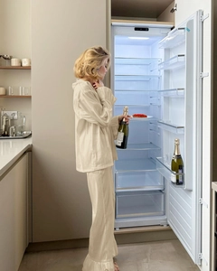 Detail of satin home wear set featuring ruffled hem pants and button-down long sleeve top