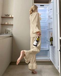 Detail of ruffled cuffs and layered hem on creamy beige long sleeve pajama set