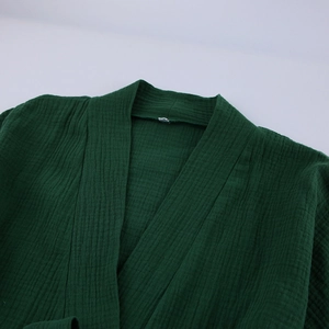 Dettaglio del pigiama in cotone crepe verde scuro con colletto a kimono e trama