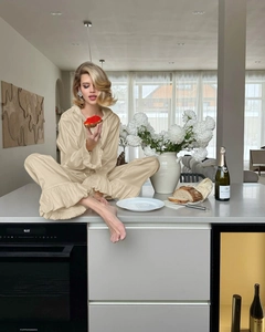 Detail of champagne satin loungewear set featuring ruffled cuffs and wide-leg pajama pants