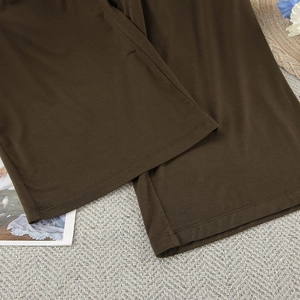 Detailed view of the dark brown modal wide-leg pants with professional hem stitching