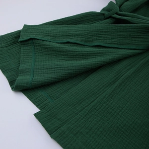 Dettaglio del pigiama in cotone stropicciato verde smeraldo con orlo e laccio in vita rifiniti