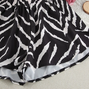 Detailed view of women's zebra print pajama shorts with elastic waistband on a beige surface