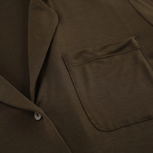 Detailed close-up of modal pajama lapel collar and chest pocket in olive brown