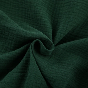 Dettaglio ravvicinato del tessuto in cotone crepe verde bosco con trama stropicciata