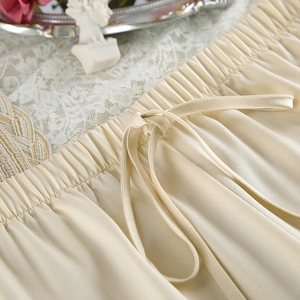 Detailed macro of the champagne satin pajama shorts featuring an elastic pleated waist with drawstring