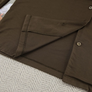 Close-up of deep coffee modal pajamas showing hem stitching and amber round buttons