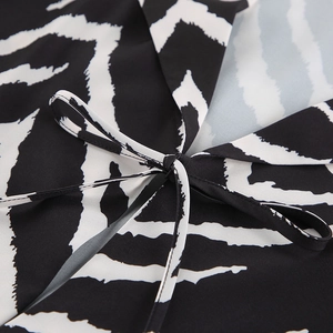 Detail of zebra print pajama set featuring a stylish bow knot and smooth woven fabric texture