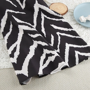 Detailed close-up of zebra print fabric on loose pajamas set with wavy black and white pattern