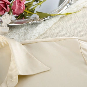 Detail of cream satin pajama top showing high-quality collar stitching and silk-like texture