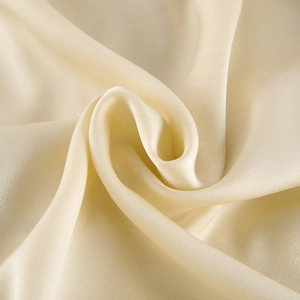 Macro view of champagne satin fabric with smooth texture and elegant drape for sleepwear