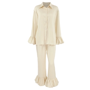 Women's cream satin pajama set featuring ruffled long sleeves and matching trousers