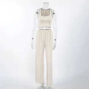 Detail of apricot milk silk pajamas featuring black contrast lettuce edge hem and soft fabric